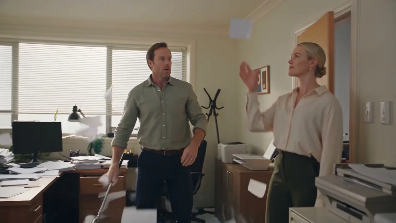 A small business office with paper everywhere, the moment the accountant walks in