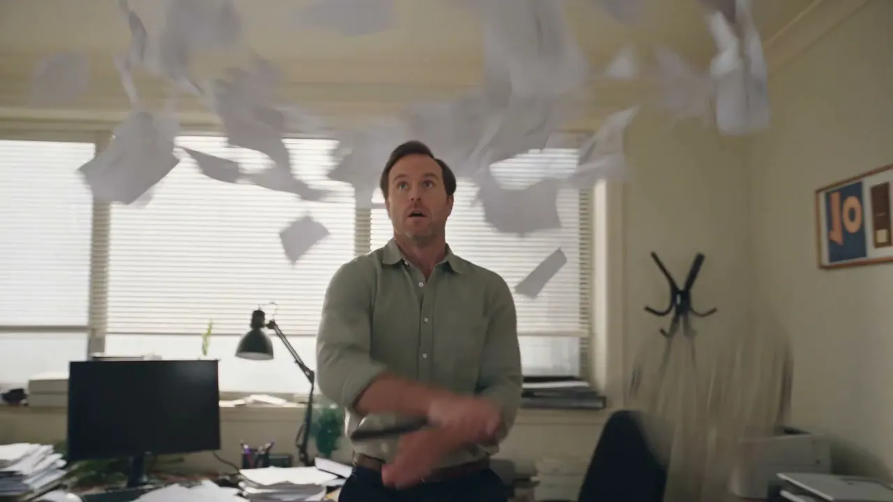 Blank paper slips in the air above a small business owner in a cluttered office