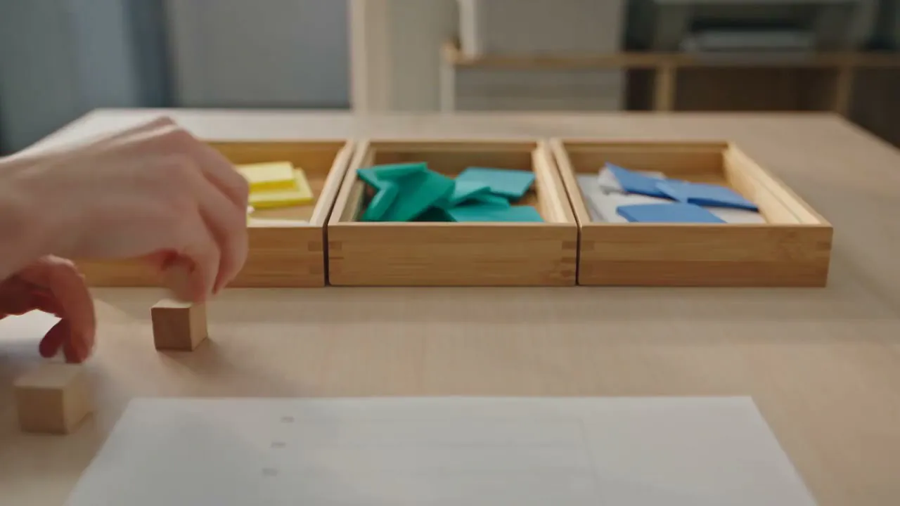 Three timber sorting trays on a birch table, part sorted, with plain coloured slips in each bay